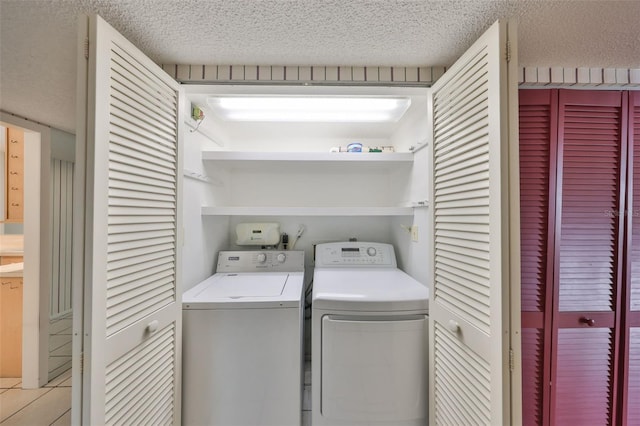 laundry room with independent washer and dryer, light tile patterned floors, and a textured ceiling