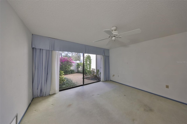 unfurnished room with ceiling fan, light carpet, and a textured ceiling