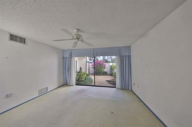 carpeted empty room featuring ceiling fan and a textured ceiling