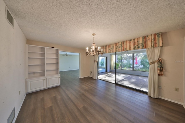 interior space featuring dark wood-type flooring, an inviting chandelier, and a textured ceiling