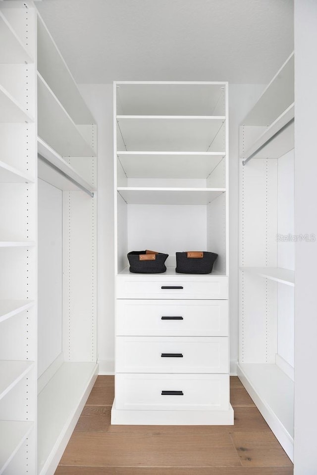 spacious closet with dark hardwood / wood-style flooring