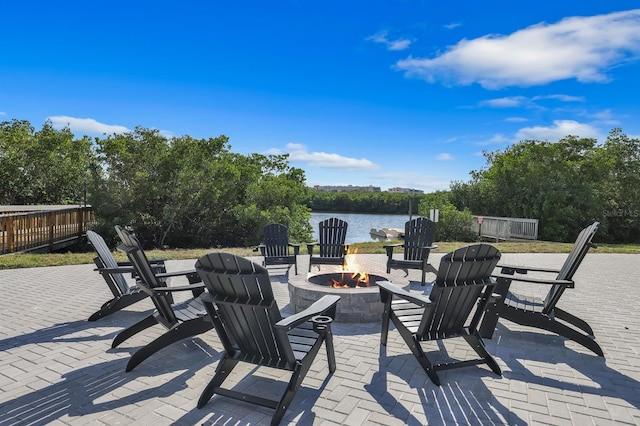 view of patio featuring a water view and a fire pit