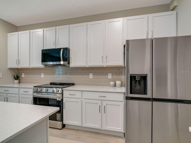 kitchen with backsplash, appliances with stainless steel finishes, and white cabinets