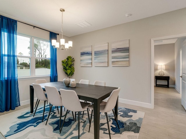 dining area with a notable chandelier and light hardwood / wood-style flooring