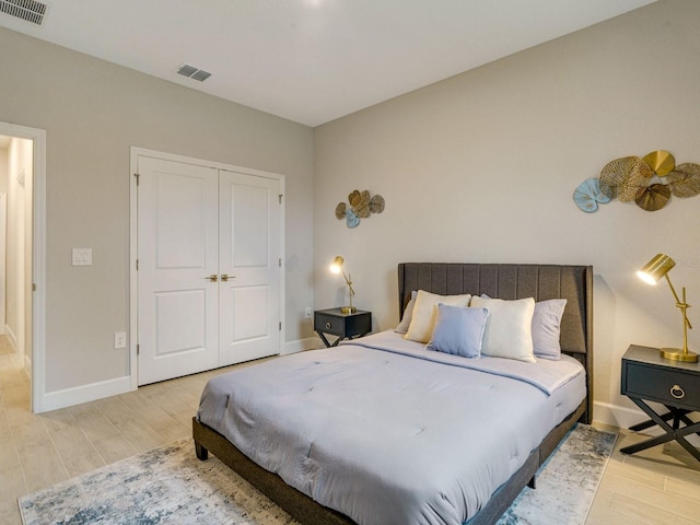 bedroom with light hardwood / wood-style floors and a closet