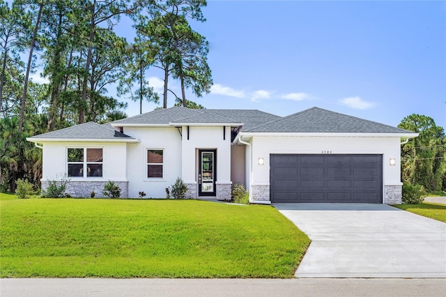 prairie-style home with an attached garage, a front yard, driveway, and stone siding