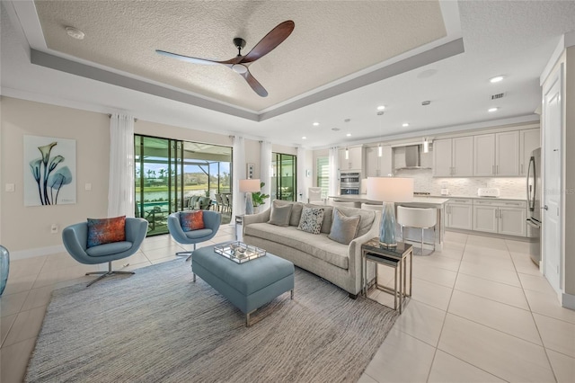 tiled living room with a textured ceiling and a tray ceiling