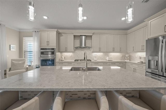 kitchen with pendant lighting, a kitchen breakfast bar, and wall chimney range hood