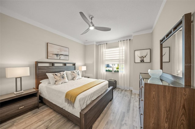 bedroom with ceiling fan, ornamental molding, a textured ceiling, and light hardwood / wood-style floors