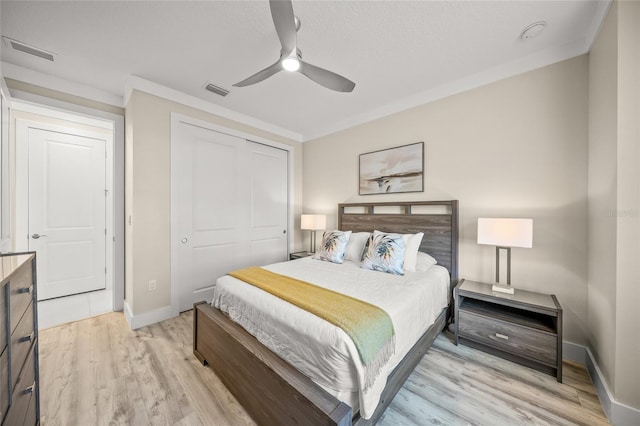 bedroom with ornamental molding, a closet, ceiling fan, and light wood-type flooring