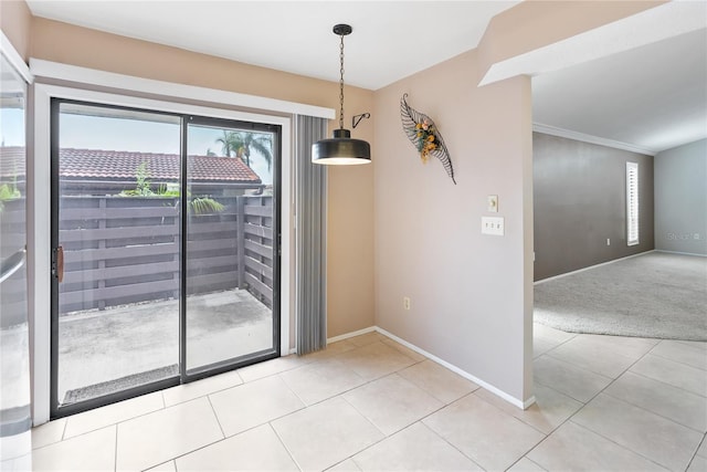 unfurnished dining area with ornamental molding and light carpet