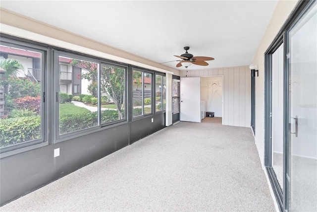 unfurnished sunroom featuring ceiling fan