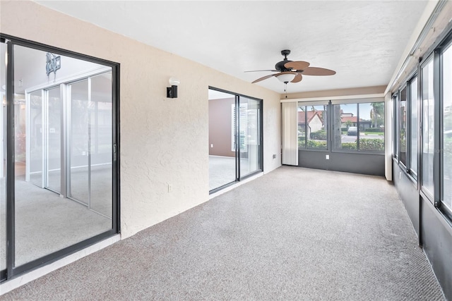 unfurnished sunroom with ceiling fan