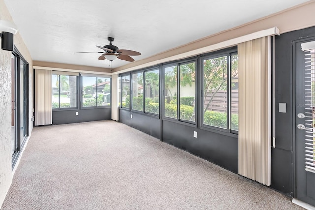 unfurnished sunroom with ceiling fan