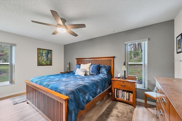 bedroom featuring a textured ceiling, ceiling fan, and light hardwood / wood-style floors