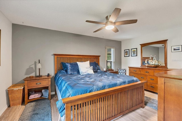 bedroom featuring ceiling fan, light hardwood / wood-style flooring, and a textured ceiling