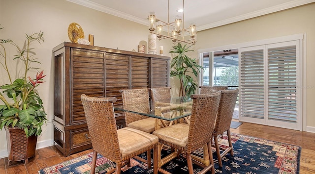 dining area featuring hardwood / wood-style flooring, ornamental molding, and a notable chandelier