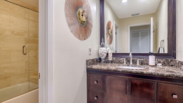 bathroom with vanity and combined bath / shower with glass door