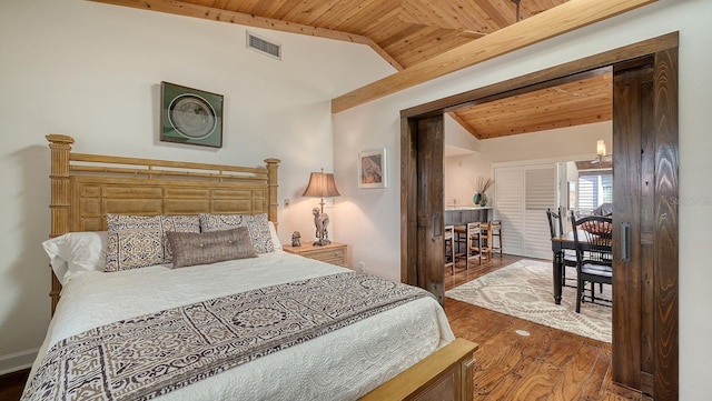 bedroom with lofted ceiling, dark hardwood / wood-style floors, and wooden ceiling