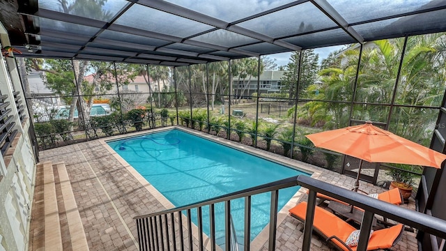 view of swimming pool featuring a patio and glass enclosure