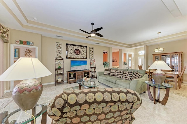 living room featuring ceiling fan and a tray ceiling