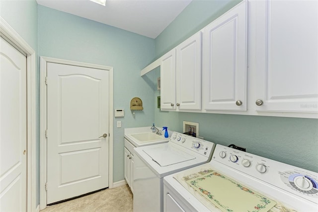 washroom with sink, independent washer and dryer, cabinets, and light tile patterned floors