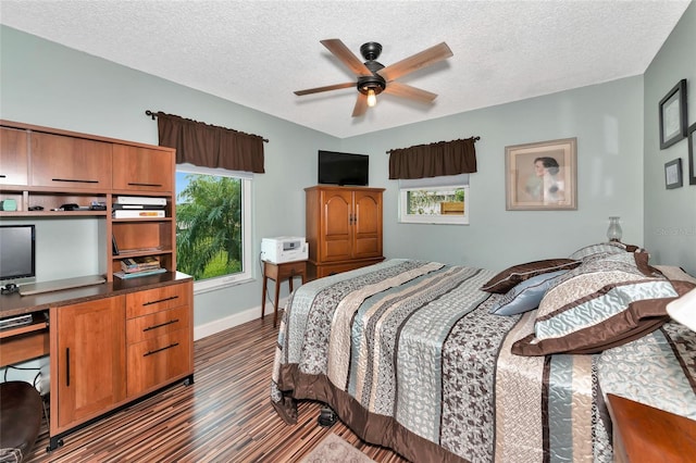 bedroom with ceiling fan, dark hardwood / wood-style floors, and a textured ceiling