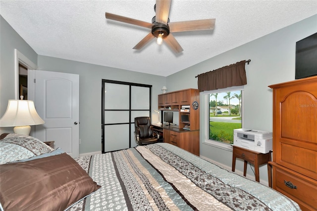 bedroom with ceiling fan and a textured ceiling