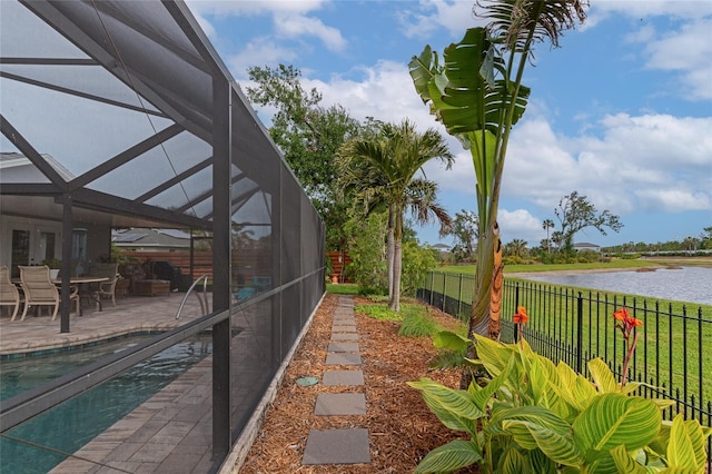 exterior space with glass enclosure, a water view, and a patio