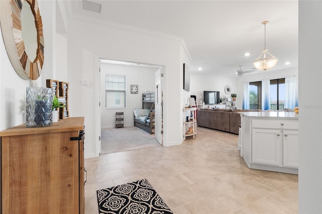 kitchen with white cabinetry, light carpet, ornamental molding, and hanging light fixtures