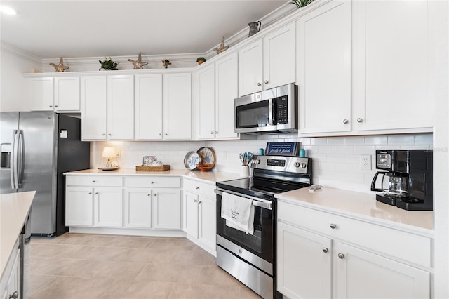 kitchen with decorative backsplash, white cabinetry, and appliances with stainless steel finishes