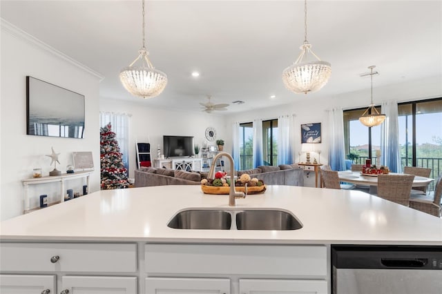 kitchen with stainless steel dishwasher, hanging light fixtures, sink, white cabinetry, and an island with sink