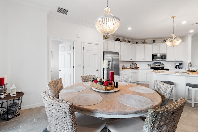 tiled dining space featuring crown molding and an inviting chandelier