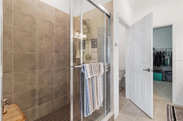 bathroom featuring toilet, walk in shower, tile patterned flooring, and crown molding