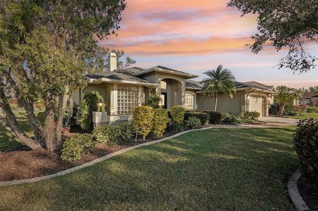 view of front of house with a garage and a yard