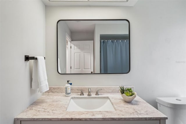 bathroom featuring vanity and toilet