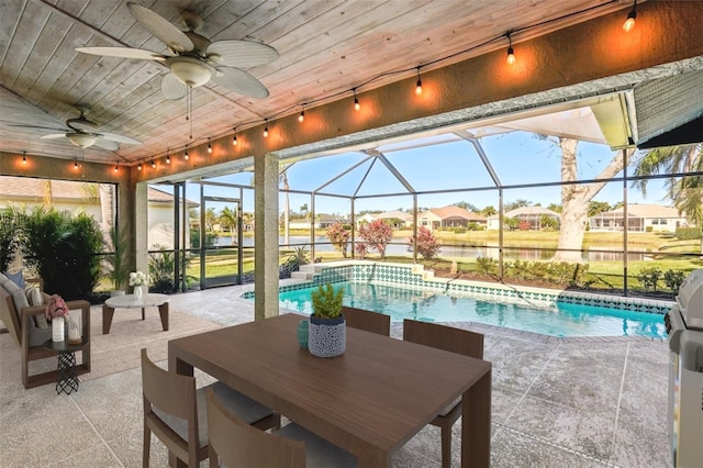 view of swimming pool featuring a patio area, ceiling fan, and glass enclosure