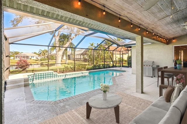 view of swimming pool featuring area for grilling, glass enclosure, an outdoor hangout area, and a patio area