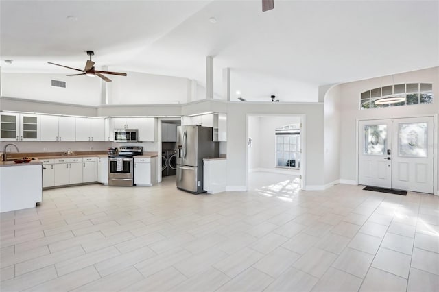 kitchen featuring sink, white cabinetry, high vaulted ceiling, appliances with stainless steel finishes, and ceiling fan