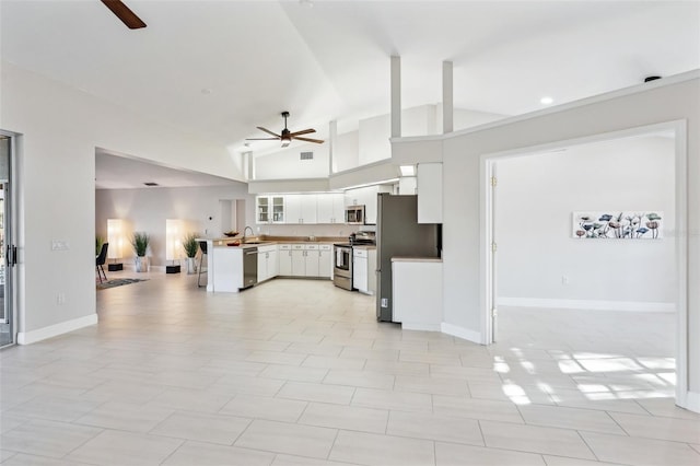 kitchen featuring sink, white cabinetry, high vaulted ceiling, appliances with stainless steel finishes, and ceiling fan