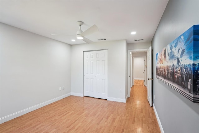 unfurnished bedroom featuring light hardwood / wood-style flooring, a closet, and ceiling fan