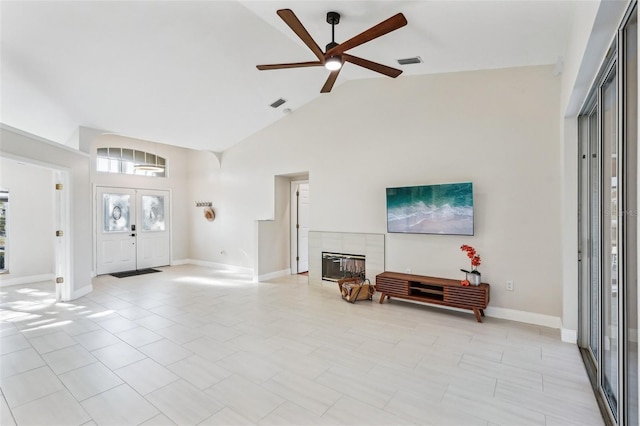 entryway with ceiling fan, a fireplace, and high vaulted ceiling