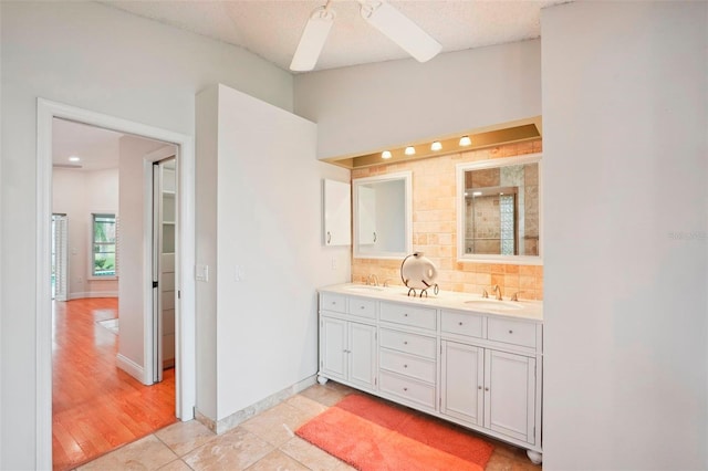 bathroom with lofted ceiling, a shower, tasteful backsplash, vanity, and ceiling fan