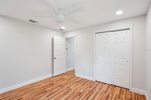 unfurnished bedroom featuring ceiling fan, a closet, and light wood-type flooring