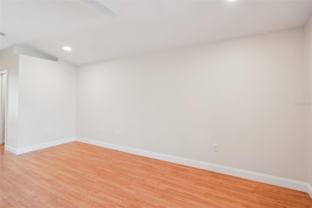 unfurnished room featuring lofted ceiling and light hardwood / wood-style floors