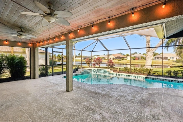 view of swimming pool with a patio, a water view, and glass enclosure