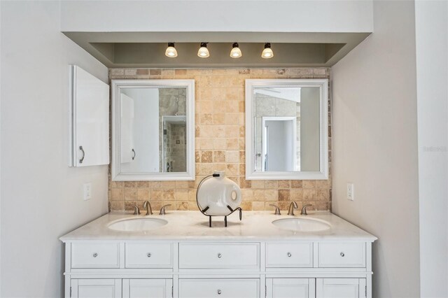 full bath with double vanity, a sink, and decorative backsplash