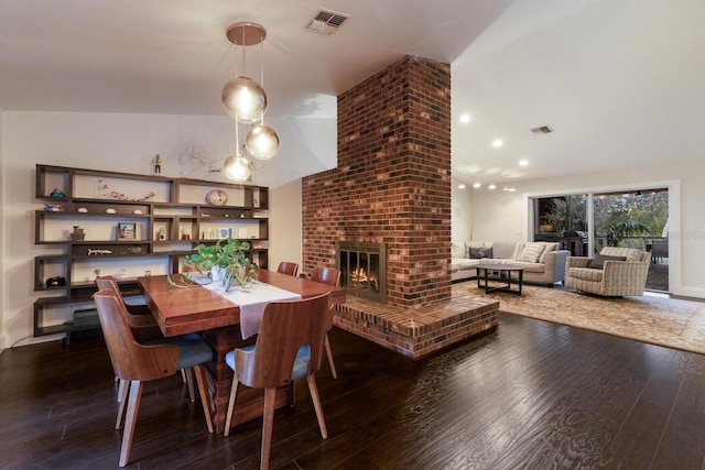 dining area with a brick fireplace, dark wood-type flooring, and vaulted ceiling