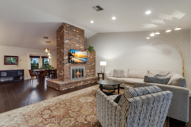 living room featuring a fireplace, dark hardwood / wood-style floors, and vaulted ceiling