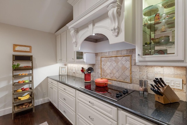 kitchen with white cabinets, custom exhaust hood, black electric stovetop, decorative backsplash, and dark hardwood / wood-style floors